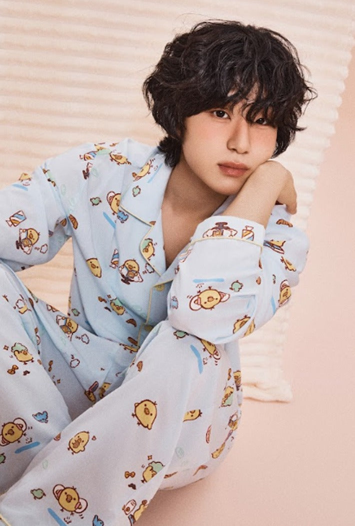 Person wearing a light blue pajama set with cartoon characters on a pink background