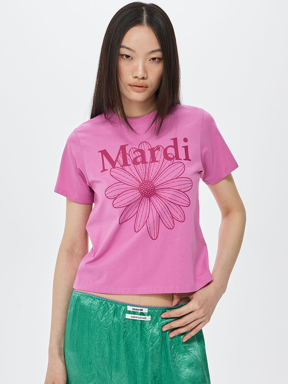 Person wearing a pink t-shirt with 'Mardi' and a flower design on a white background