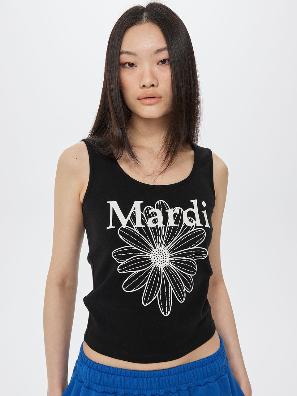 Woman wearing a black tank top with a floral design and 'Mardi' text on a white background