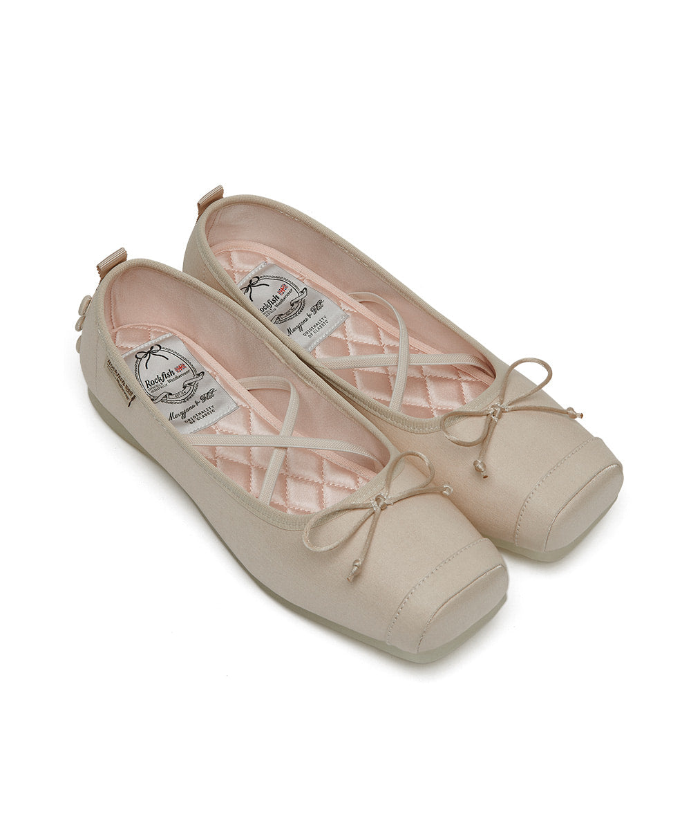 Pair of beige ballet flats with bow details on a white background