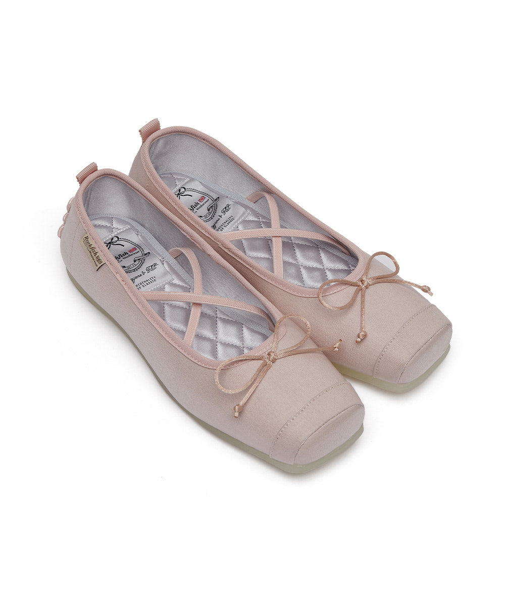 Pair of light pink ballet flats with bow details on a white background