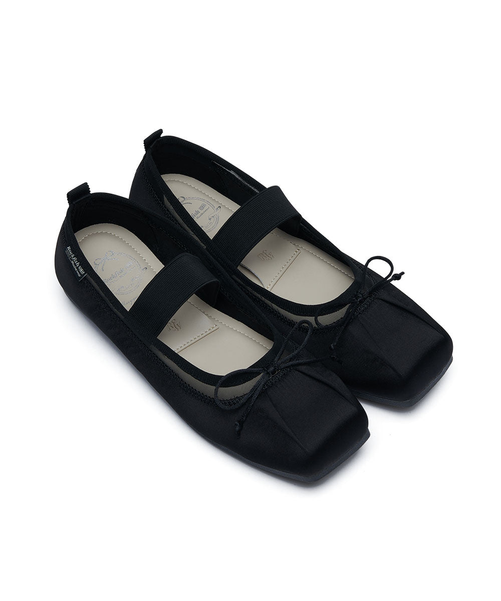 Pair of black ballet flats on a white background