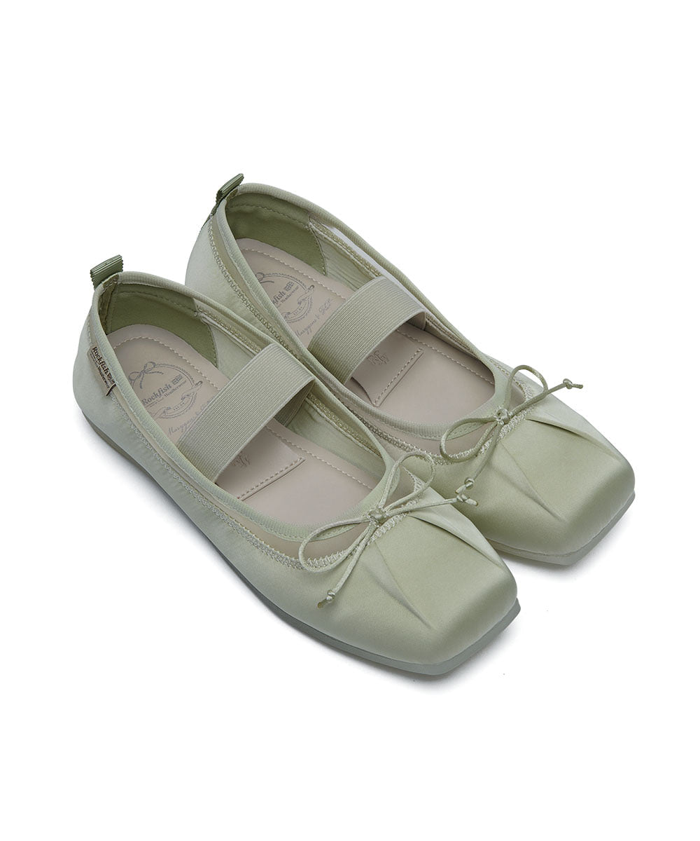 Pair of light green flat shoes on a white background